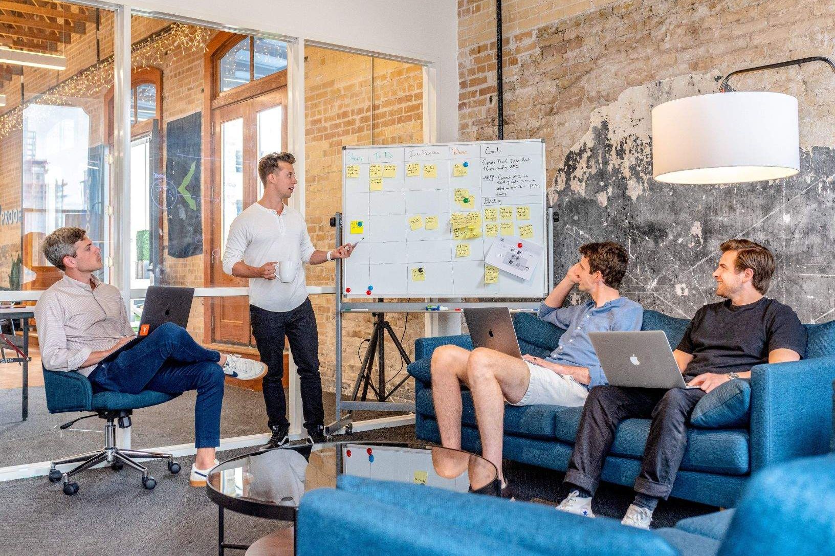 A group of workers having a dicussion infront of a whiteboard